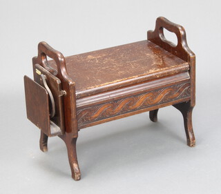 A 1930's carved oak twin handled sewing stool with hinged lid 42cm h x 47cm w x 29cm d 