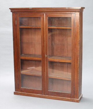 A Victorian mahogany bookcase fitted shelves enclosed by glazed panelled doors on a platform base 136cm h x 110cm w x 26cm d (hole to the top, two screw repairs to front)  