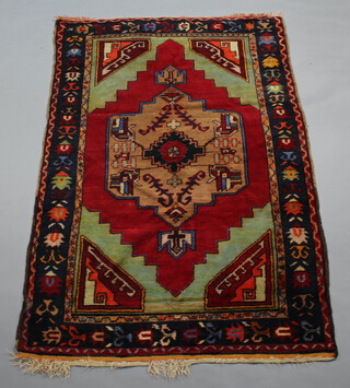 An Afghan red and green ground rug with central medallion within multi row border 216cm x 140cm 