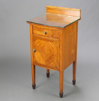 An Edwardian inlaid and crossbanded satinwood bedside cabinet with raised back fitted a drawer above bow front panelled door, raised on square tapered supports, spade feet 85cm h x 41cm w x 39cm d 
