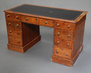 A Victorian oak pedestal desk with inset black leather writing surface above 1 long and 8 short drawers with replacement handles 68cm h x 120cm w x 59cm d 