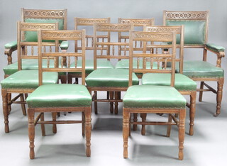 A set of 9 Victorian carved oak aesthetic movement dining chairs upholstered in green rexine, raised on turned supports with H framed stretchers - 2 carvers, 7 standard chairs