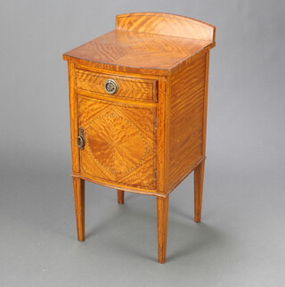 An Edwardian Georgian style bow front satinwood bedside cabinet with arch shaped raised back fitted a drawer above cupboard with garland inlay, raised on square tapered supports 81cm h x 40cm w x 44cm d 