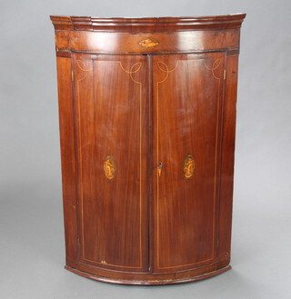 A Georgian inlaid mahogany bow front hanging corner cabinet enclosed by panelled doors 105cm h x 71cm w x 50cm d 