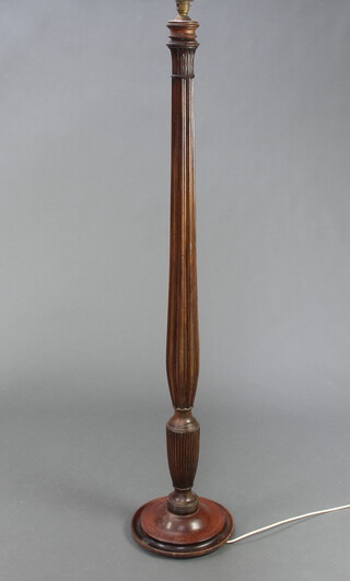 A William IV turned and fluted mahogany bed post converted for use as a standard lamp, raised on a circular spreading base 137cm h x 30cm diam. 