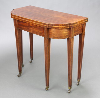 An Edwardian Georgian style inlaid shaped mahogany tea table, raised on square tapered supports ending in brass caps and casters 73cm h x 81cm w x 40cm d  