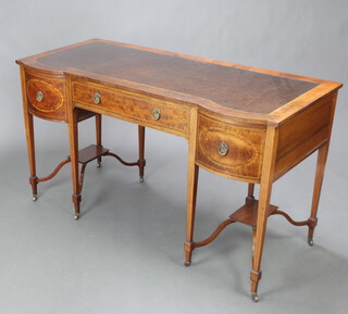 An Edwardian Sheraton Revival shaped inlaid mahogany writing table with inset writing surface above 1 long and 2 short drawers, raised on square tapered supports ending in brass caps and casters 76cm h x 135cm w x 61cm d 