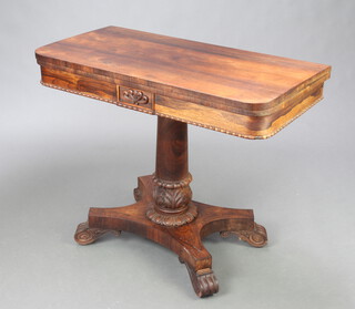 A William IV carved rosewood card table raised on turned column and triform base with scroll feet 75cm h x 92cm w x 46cm d 