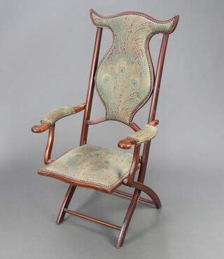 An Edwardian Art Nouveau mahogany folding campaign armchair upholstered in Morris style material 112cm h x 51cm w x 44cm d  