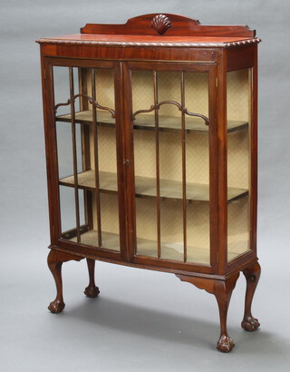A 1930's Chippendale style mahogany bow front display cabinet with raised back, interior fitted adjustable shelves enclosed by glazed panelled doors, raised on cabriole, ball and claw supports 136cm h x 91cm w x 36cm d 
