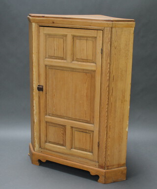 A Victorian pine corner cabinet with moulded cornice, fitted adjustable shelves enclosed by panelled door, raised on a platform base 132cm h x 103cm w x 66cm d 