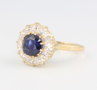 An 18ct yellow gold sapphire and diamond cluster ring, the centre brilliant cut sapphire approx. 1.25ct, surrounded by 12 brilliant cut diamonds approx. 0.60ct, 4.7 grams size M