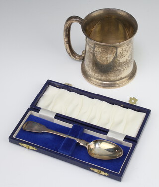 A silver mug of plain form with C scroll handle and engraved monogram Birmingham 1922 together with a silver teaspoon 188 grams 