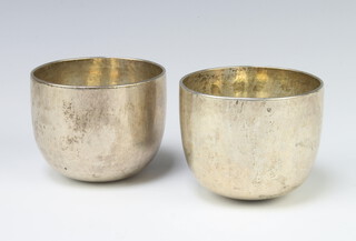A pair of Georgian white metal tumbling cups of plain form 6cm, 397 grams 