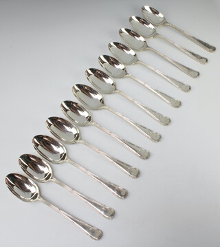 A set of 12 ribbon and bow silver table spoons Birmingham 1909, 1086 grams 