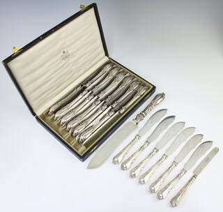 A cased set of 12 silver handled lily pattern dinner knives together with a ditto bread knife, 6 fish knives and a dessert knife
