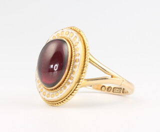 A 9ct yellow gold cabochon cut oval garnet and enamel ring, size S, 7 grams