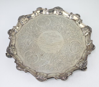 A George II silver salver with Chippendale rim, scroll decoration and later inscription, dated 1840, the salver raised on scroll feet, 32cm diam. London 1755, 910 grams 