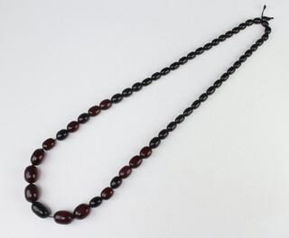 A set of red graduated amberoid beads 98 cm