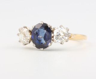 An 18ct. yellow gold 3 stone sapphire and diamond ring, the centre oval cut sapphire approx. 1.25ct, the mine cut diamonds each approx. 0.5ct, 4 grams