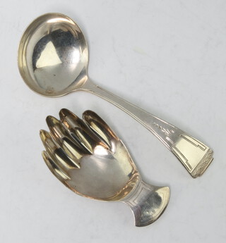 A silver caddy spoon with bright cut decoration Sheffield 1939, another in the form of a hand 27.5 grams