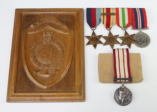 A group of five medals to P0/X.5111 L.G.Elliott Marine Royal Marines comprising 1939-45 Star, Africa Star with clasp North Africa 1942-43, Italy Star, British War medal and Naval General Service medal 1915-1962 one bar Malaya 1935-45, together with a rectangular hardwood plaque carved Royal Marines badge marked Italy 1945 HQ Troop 40 Commando Royal Marines P Per Mare Per Terram 21cm x 15cm (PLEASE NOTE the recipients dagger is to be sold as lot 680 in this Auction)