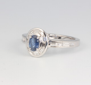 An 18ct white gold oval sapphire and diamond ring, sapphire approx. 0.45ct, the baguette cut diamonds 0.5ct, 4.8 grams, size M 