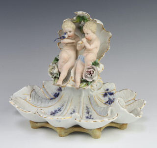 A 19th Century German centrepiece in the form of 2 cherubs sitting inside a shell with flowers and shell base 30cm