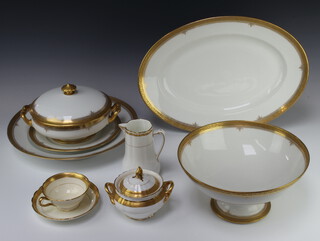 A Mansard French gilt decorated dinner service comprising 9 small plates, 8 dinner plates, 2 oval meat plates, shallow serving dish, tazza (a/f), tureen and cover (a/f), a pedestal bowl, 16 shallow bowls and a tureen and cover (all show some wear), together with 9 French 19th Century dinner plates with monogram (rubbed), 5 Mintons tea cups and saucers, 9 similar gilt china (all with some wear) 