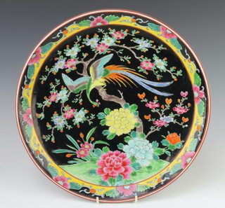 A 20th Century Japanese charger, the black ground decorated with an exotic bird amongst trees and flowers 37cm 