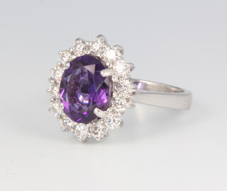 An 18ct white gold oval amethyst and diamond cluster ring, the centre stone approx. 2.11ct, brilliant cut diamonds 0.74ct, size M, 6.7 grams