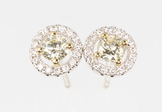 A pair of 18ct white gold halo stud earrings approx. 0.69ct 7mm, complete with WGI certificate, 2.6 grams