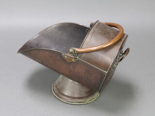 A Victorian copper helmet shaped coal scuttle raised on a circular spreading foot 33cm x 50cm x 32cm 