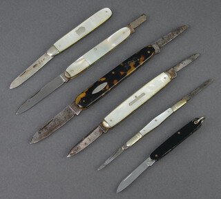 A silver bladed folding cake knife with mother of pearl grip, 2 double bladed folding pen knives with m.o.p grips (both with damaged grips, 1 with missing blade) and 2 other folding pen knives  