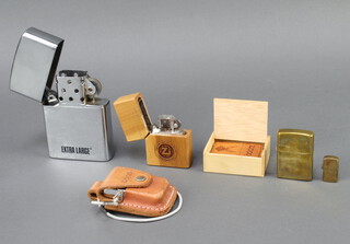 Two Zippo lighters contained in leather cases, ditto in wooden case, a brass cased ditto together with an extra large Zippo style lighter 11cm x 7cm x 2cm and a miniature Zippo style lighter 3cm x 2cm x 1cm  