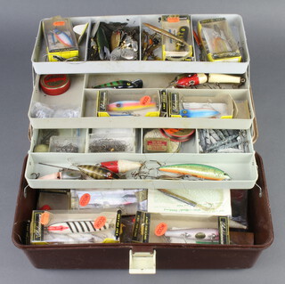 A large collection of 1970's vintage fishing lures including 10 unused and boxed Shakespeare lures, mainly wooden and loose examples, Jardin weights, floats etc, contained in a brown plastic cantilever tackle box  