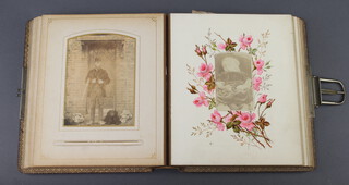 A Victorian leather bound photograph album containing a collection of black and white portrait photographs (binding showing signs of deterioration) 
