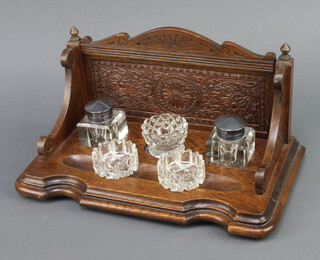An Edwardian carved oak standish with raised back fitted 2 associated cut glass inkwells and 3 circular cut glass desk tidies 17cm h x 32cm w x 18cm d 