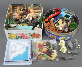 A collection of 1960's/70's Britains plastic zoo animals together with caging and a collection of various farm animals contained in 2 tins 