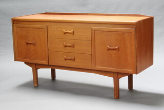 A mid Century teak sideboard with raised back above 3 drawers flanked by cupboards, raised on square supports 78cm h x 144cm w x 42cm d (water stains to the top) 