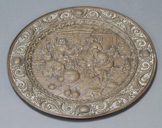 A circular embossed brass charger decorated a tavern scene 63cm diam. 