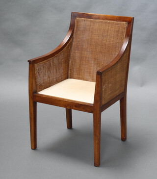 A hardwood bergere style double cane library chair, raised on square tapered supports 88cm h x 54cm w x 47cm d (seat 34cm x 31cm, there is damage to the left hand section of cane) 