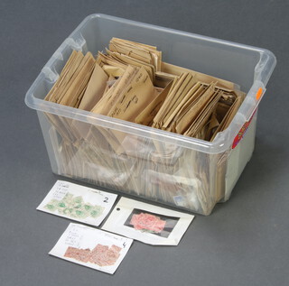 A collection of used GB and world stamps contained in a plastic crate 