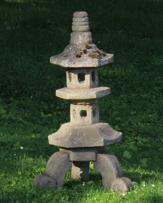 A well weathered hexagonal reconstituted stone 2 tier model of a pagoda raised on scroll supports in 4 sections 82cm h x 50cm w 