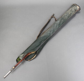 A 1960's green plastic fishing rod holdall containing an Abu All England match rod, spinning road, a cane fly rod and a landing net 