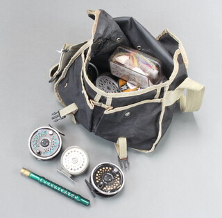 A Shakespeare cloth fishing bag containing 2 dragonfly 120 reels, 1 other reel, spare spools etc 