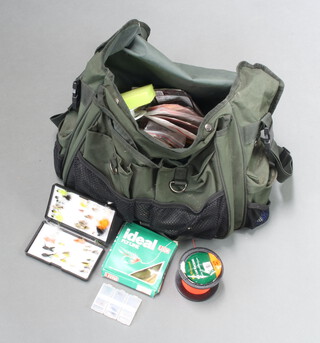 A collection of fly fishing tackle including fly lines, leaders, flies etc in a large green canvas bag 