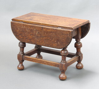 A 17th Century style oak drop flap occasional table raised on cup and cover supports with bun feet 41cm h x 53cm w x 25cm d 
