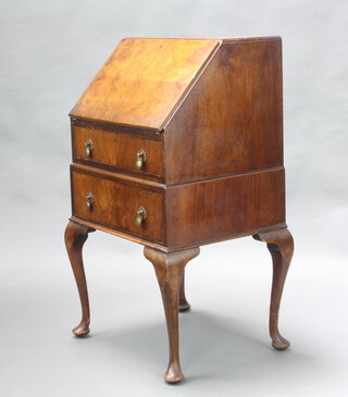 A 1930's figured walnut bureau, the fall front above 2 drawers, raised on cabriole supports 96cm h x 53cm w x 44cm d 