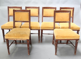 In the manner of Bruce Talbot, a set of 6 mahogany aesthetic movement dining chairs, the seats and backs upholstered in yellow material, raised on turned supports (1 stretcher missing) 85cm h x 47cm w x 45cm d (seat 33cm x 30cm)  This lot requires restoration and re-upholstering  